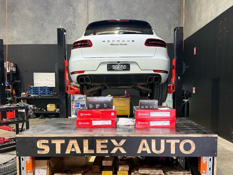 White Porsche Macan Turbo 2016 on the hoist at StalexAuto with Brembo brake pads and discs for a full brake service